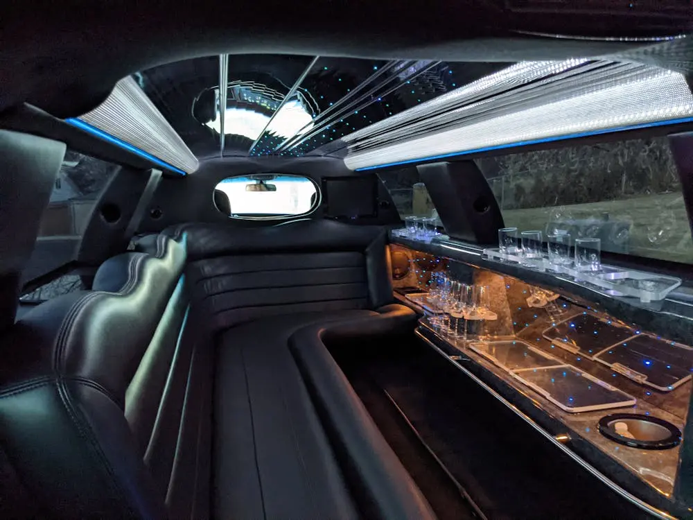 Limousine interior with black leather bench seating and a bar